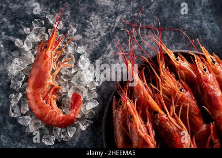 Hoher Garnelenwinkel in einer Schüssel mit Eis und Petersilie auf einem schwarzen Tisch im Luxusrestaurant Stockfoto