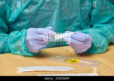 Anonymer Arzt mit medizinischen Handschuhen, der Tropfen auf einen schnellen Coronavirus-Test in der Klinik setzte Stockfoto