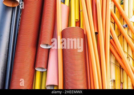 Kunststoffrohre in schwarz, rot, orange und gelb. Stockfoto