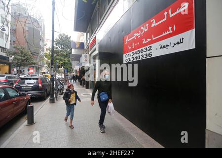 Beirut, Libanon. 10th Januar 2022. Am 10. Januar 2022 gehen Menschen an einem geschlossenen Geschäft in Beirut, Libanon, vorbei. Libanesische Händler wurden 2021 von der beispiellosen Wirtschafts- und Finanzkrise des Landes getroffen, bei der laut der Beirut Traders Association 35 Prozent von ihnen ihre Geschäfte oder einige Filialen schlossen. Quelle: Bilal Jawich/Xinhua/Alamy Live News Stockfoto