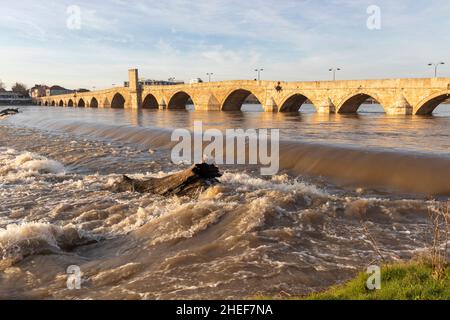 SVILENGRAD, BULGARIEN - 31. DEZEMBER 2021: Blick auf den Sonnenuntergang über der Mustafa Pasha Brücke aus dem 16. Jahrhundert über dem Fluss Maritsa, Svilengrad, Bulgarien Stockfoto