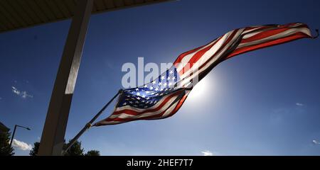 Die Sonne scheint durch eine amerikanische Flagge. Stockfoto