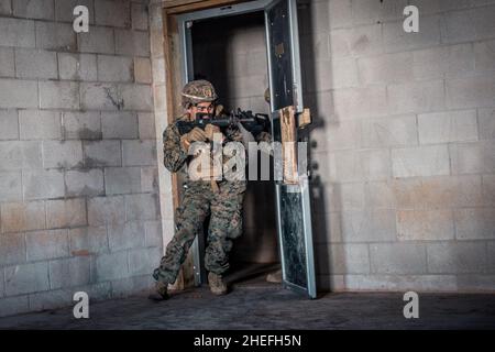 Marines with Echo Company, 2nd Bataillon, 23rd Marine Regiment, 4th Marine Division, werden am 9. Januar 2022 in Fort Pickett, Virginia, Kampfübungen in einem militärischen Einsatzort im Trainingsdorf Urban Terrain (MOUT) unterzogen. MOUT Villages simulieren die urbane Landschaft, in der sich Marines befinden können, während sie sich in Nahbereichen befinden. Das Verteidigungsministerium stellt über das Northern Command der USA und zur Unterstützung des Heimatschutzministeriums Transport, vorübergehende Unterbringung, medizinische Vorsorgeuntersuchungen und allgemeine Unterstützung für mindestens 50.000 afghanische Evakuierte zur Verfügung Stockfoto