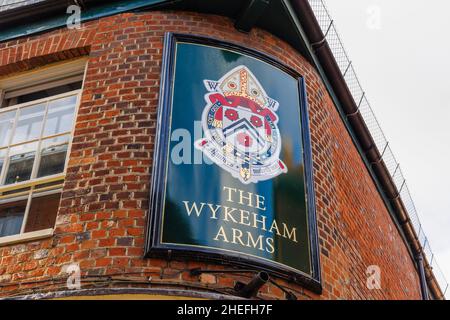 Schild vor den Wykeham Arms mit dem Motto von Winchester College, „Manners makyth man“, Kingsgate Street, Winchester, Hampshire, England Stockfoto