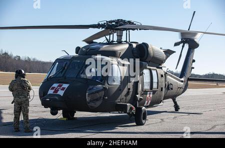 US Army Staff Sgt. Jacob Eyer, der Abteilung Eins, Charlie Company, 1st Bataillon, 111th Aviation Regiment, steht vor einem HH-60 Black Hawk Hubschrauber, während er am Newnan Coweta County Airport, Newnan, Georgia, herunterfährt, 8. Januar 2022. Diese Flieger fliegen, um über ihren Flugstatus auf dem neuesten Stand zu bleiben und ihre Kriegeraufgaben und -Übungen zu beherrschen. (USA Army Reserve Foto von Staff Sgt. Austin Berner) Stockfoto