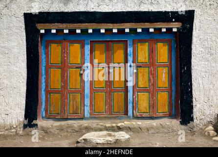 Farbfoto von drei farbenfrohen tibetischen Türen eines weiß getünchten Steingebäudes, Zsarang, Himalaya, Nepal, Asien, 2011. Stockfoto