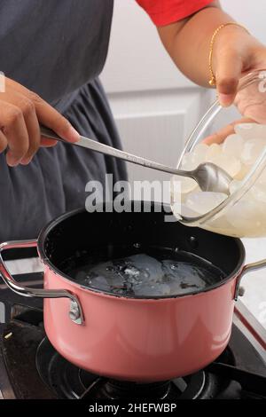 Boliling Sugar Palm Fruit oder Kolang Kaling, Prozess Herstellung Ramadan Desser, Manisan Kolang Kaling mit Zuckersirup Stockfoto