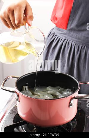 Gießen Sie einfachen Sirup oder Zuckersirup oder flüssigen Zucker in die Pfanne und verarbeiten Sie Manisan Kolang Kaling (Sugar Palm Fruit) für Ramadan oder IED Fitr Stockfoto