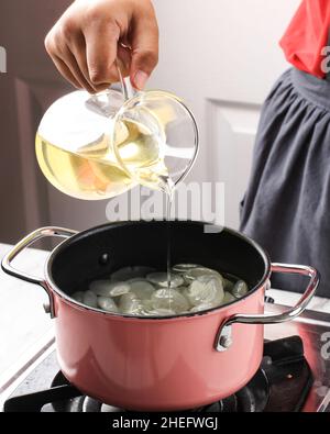 Gießen Sie einfachen Sirup oder Zuckersirup oder flüssigen Zucker in die Pfanne und verarbeiten Sie Manisan Kolang Kaling (Sugar Palm Fruit) für Ramadan oder IED Fitr Stockfoto