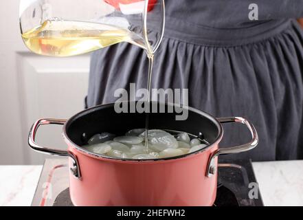 Gießen Sie einfachen Sirup oder Zuckersirup oder flüssigen Zucker in die Pfanne und verarbeiten Sie Manisan Kolang Kaling (Sugar Palm Fruit) für Ramadan oder IED Fitr Stockfoto