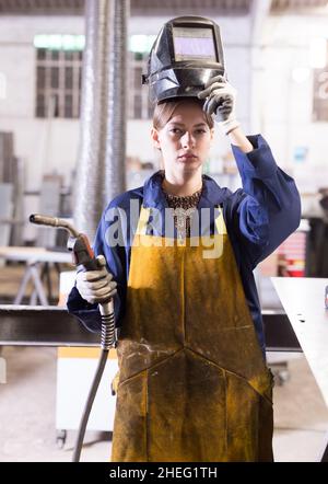 Junge Frau, die Schweißer für Bauarbeiten verwendet Stockfoto