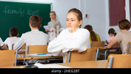 Trauriges Teenager-Mädchen im Klassenzimmer während des Unterrichts Stockfoto