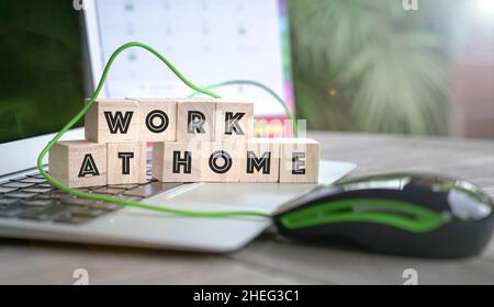 Arbeiten zu Hause, Wort auf Holzwürfel auf der Computertastatur geschrieben. Stockfoto