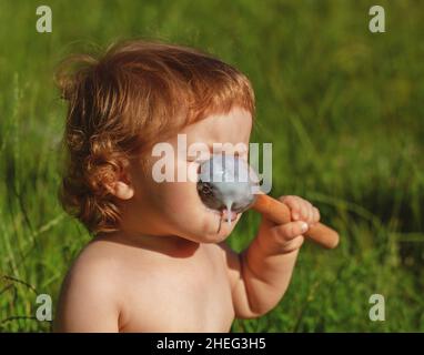 Lachend essen Baby Mädchen mit schmutzigem Gesicht. Stockfoto