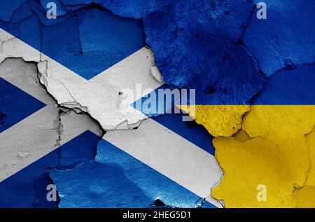 Flaggen von Schottland und der Ukraine auf rissige Wand gemalt Stockfoto