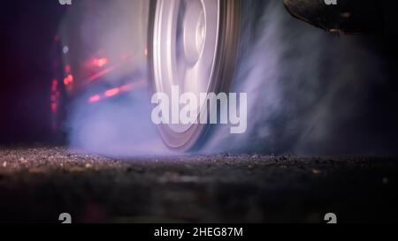 Ziehen Sie den brennenden Reifen des Rennwagens an der Startlinie auf der Rennstrecke Stockfoto