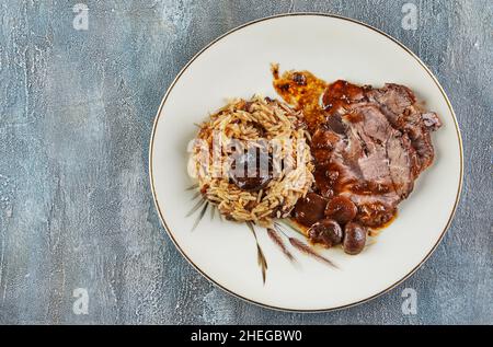 Rindfleisch in Sauce mit Pilzen und Kastanien und Risotto. Französische Gourmetküche Stockfoto
