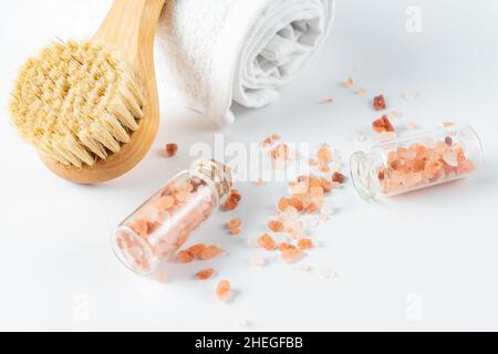 Spa-Behandlungskonzept. Natürliche, organische Spa-Kosmetikprodukte, Massagebürste und rosa Hymalayan-Salz auf weißem Tisch Spa-Hintergrund. Stockfoto