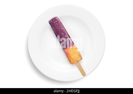 Obst-Eis auf einem Stock-in-Teller auf weißem Hintergrund, Draufsicht. Gefrorener Saft, schwarze Johannisbeere und Mango. Stockfoto