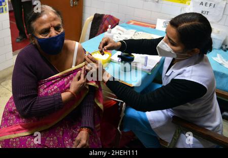 Neu-Delhi, Indien. 10th Januar 2022. Eine Gesundheitsarbeiterin verabreicht einer Frau in Neu-Delhi, Indien, die dritte Dosis des COVID-19-Impfstoffs, 10. Januar 2022. Quelle: Partha Sarkar/Xinhua/Alamy Live News Stockfoto