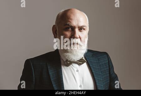 Älterer Mann. 60 Jahre alter Mann. Zufrieden reifen Geschäftsmann Blick auf Kamera isoliert auf grau. Stockfoto