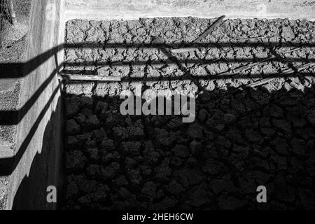 Abstrakte Schattenmuster auf getrocknetem und rissem Schlamm im Boden eines Wassertanks in der Nähe von Las Vegas, Teneriffa, Kanarische Inseln, Spanien Stockfoto