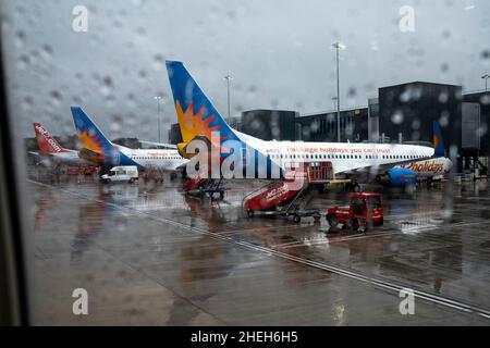 Jet 2 Ferienflugzeug durch das Fenster eines Flugzeugs im Regen auf dem Boden am Flughafen Manchester, England, Großbritannien, gesehen Stockfoto