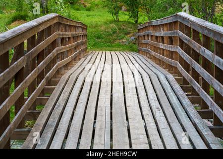 VALLDAL, NORWEGEN - 2020. JUNI 06. Brücke über den Fluss im Wald. Stockfoto