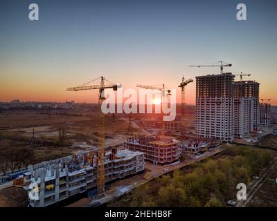 Sonnenuntergang auf einer Baustelle mit Kränen, die neue Häuser bauen Stockfoto