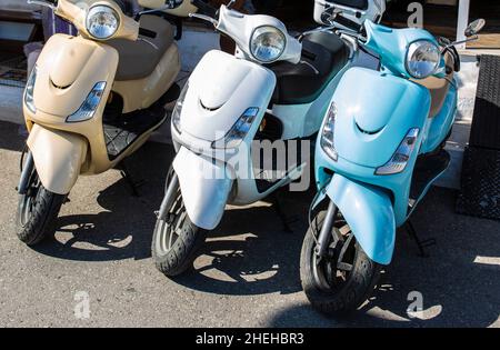 Mopeds Reihen sich auf der Straßenseite an, um auf einer griechischen Hauptstraße verkauft zu werden Stockfoto