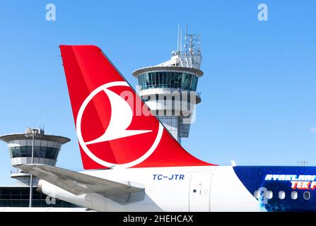 Turkish Airlines Logo auf den Schwänzen eines Airbus A321-Flugzeugs mit einem Flugsicherungsturm im Hintergrund. Stockfoto