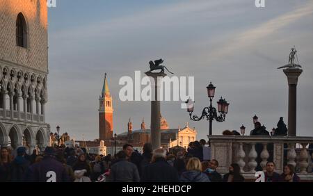 Viele Touristen strömen an einem Herbsttag auf den Markusplatz. Kirche San Giorgio im Hintergrund Stockfoto