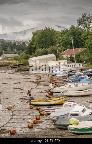 Boote auf der Afon Seiont in Caernarfon bei Ebbe mit den Hügeln von Snowdonia dahinter Stockfoto