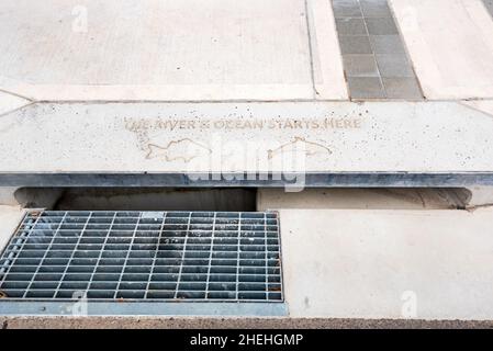 Neuer Straßenpfad und Dachrinne (Rinne) und ein Abfluss mit einer Anti-Müll-Verschmutzungsmeldung, die im Beton in Newcastle, Australien, eingestanzt ist Stockfoto