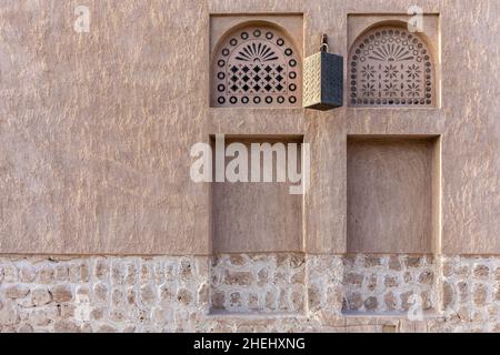 Fensterportale im arabischen Stil in Steinmauer mit Ornamenten, traditionelle arabische Architektur, Al Fahidi, Dubai, Vereinigte Arabische Emirate, Speicherplatz kopieren. Stockfoto