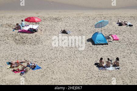 File Photo vom 20/05/20 von Menschen, die sich sozial distanziert haben, als sie sich am Bournemouth Beach in Dorset sonnen, als die Lockerung der Sperrmaßnahmen hereinsetzte. Die Polizei steht mit dem Kabinettsbüro in Kontakt, da behauptet wird, Martin Reynolds, der wichtigste Privatsekretär des Premierministers, organisierte während der ersten englischen Sperre am 20. Mai 2020 im Garten hinter der Nummer 10 eine "Bring Your Own Booze"-Party. Ausgabedatum: Dienstag, 11. Januar 2022. Stockfoto