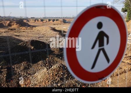 Erftstadt, Deutschland. 11th Januar 2022. Am Zaun an der Kiesgrube im Stadtteil Blessem hängt das Verkehrsschild „Fußgängerverbot“. Wegen des schweren Erdrutsches in Erftstadt während der Hochwasserkatastrophe im Sommer 2021 haben Ermittler mit Durchsuchungen gegen mehrere Verdächtige gehandelt. Mehr als 140 Polizisten durchsuchten mehr als 20 Büro- und Wohnanschriften. (An dpa: 'Hochwassererdrutsch in Erftstadt: Durchsuchungen beim Tagebaubetreiber') Quelle: Oliver Berg/dpa/Alamy Live News Stockfoto