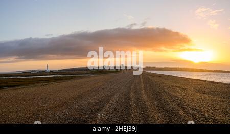 Kieselsteinspieß bei Sonnenaufgang, der zur englischen Militärfestung von Hurst Castle und zum Leuchtturm von Hurst Point in der Ferne führt. Stockfoto