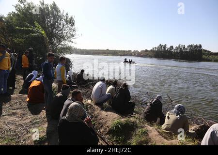 Kairo, Ägypten. 11th Januar 2022. Zuschauer beobachten, wie Rettungskräfte von einem Lastwagen, der am 11. Januar 2022 in Gizeh, Ägypten, in den Nil stürzte, nach vermissten Menschen suchen. Mindestens zwei Menschen wurden getötet und acht weitere werden in Ägypten noch vermisst, als ein Lastwagen mit 24 Passagieren in den Nil in der Nähe der Hauptstadt Kairo stürzte, teilte die ägyptische Staatsanwaltschaft am Dienstag in einer Erklärung mit. Quelle: Ahmed Gomaa/Xinhua/Alamy Live News Stockfoto