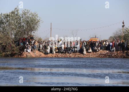 Kairo, Ägypten. 11th Januar 2022. Zuschauer beobachten, wie Rettungskräfte von einem Lastwagen, der am 11. Januar 2022 in Gizeh, Ägypten, in den Nil stürzte, nach vermissten Menschen suchen. Mindestens zwei Menschen wurden getötet und acht weitere werden in Ägypten noch vermisst, als ein Lastwagen mit 24 Passagieren in den Nil in der Nähe der Hauptstadt Kairo stürzte, teilte die ägyptische Staatsanwaltschaft am Dienstag in einer Erklärung mit. Quelle: Ahmed Gomaa/Xinhua/Alamy Live News Stockfoto