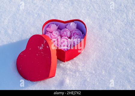 Geschenkverpackung in Herzform mit einem Geschenk für eine Dame am Valentinstag oder 8. März Stockfoto