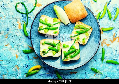 Gemüsebruschetta mit Brokkoli, grünen Erbsen und Spargelbohnen.Vegetarisches Essen Stockfoto