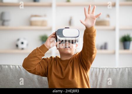 Aufgeregt Kind mit VR-Brille, berühren etwas Unsichtbares Stockfoto