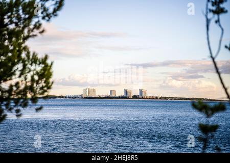 Stadtbild von Troia bei Sonnenuntergang mit Atlantik und Bäumen im Vordergrund, neben Setubal, Portugal Stockfoto