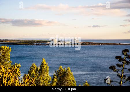 Stadtbild von Troia bei Sonnenuntergang mit Atlantik und Bäumen im Vordergrund, neben Setubal, Portugal Stockfoto