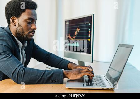 Fokussierter männlicher Händler mit Laptop Stockfoto