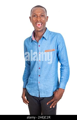 Ein erwachsener Geschäftsmann trägt ein elegantes blaues Hemd, lächelt und hält seine Finger in den Taschen. Stockfoto