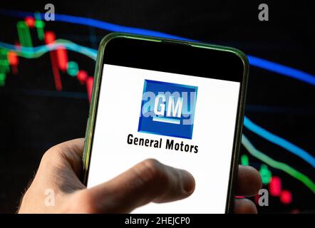 Auf dieser Fotolabbildung ist das Logo des amerikanischen multinationalen Automobilkonzerns General Motors (GM) zu sehen, das auf einem Smartphone mit einem Index-Diagramm der wirtschaftlichen Börse im Hintergrund zu sehen ist. Stockfoto