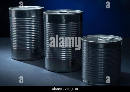 Helsinki / Finnland - 11. JANUAR 2022: Nahaufnahme von zwei Metalldosen vor blauem Hintergrund. Stockfoto