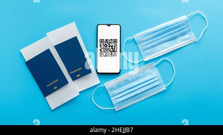 QR-Code des Impfstempels für negative covid PCR-Tests auf dem Smartphone-Bildschirm. Green-Pass-Zertifikat für Flugzeug fliegen. Medizinische Masken, Pässe Flugzeug Stockfoto